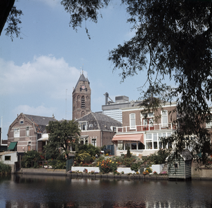 119947 Gezicht over de gracht op de achtergevels van enkele huizen aan de Westerwal te Oudewater met op de achtergrond ...